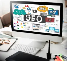 A desktop monitor shows a hand-drawn mind map centered on the word SEO, surrounded by technology and content concepts